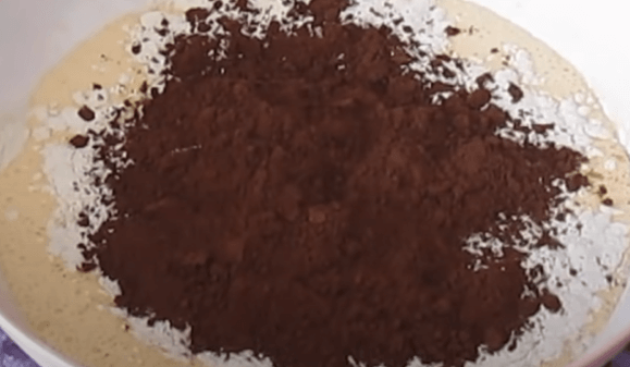 Flour and cocoa powder added to the chocolate cake batter