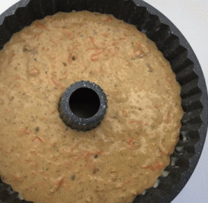 Carrot and walnut cake batter in a greased bundt pan