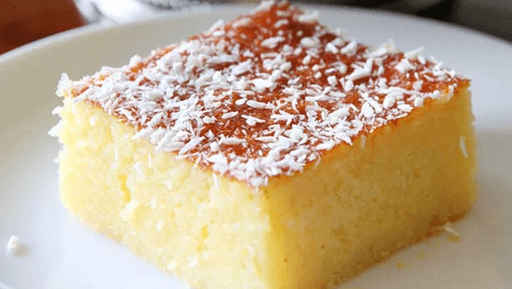 A slice of Turkish semolina cake topped with coconut.