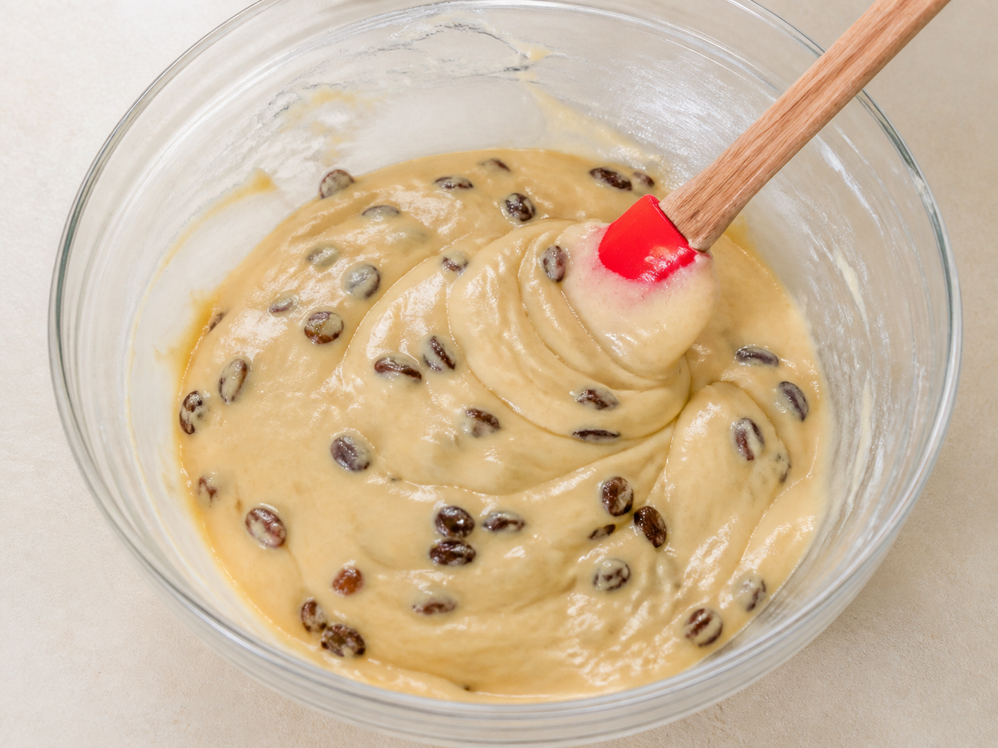 Orange raisin cake batter fully combined with a spatula